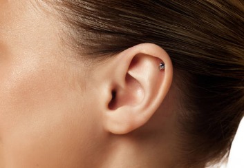 A hoop earring between the earlobe and upper ear